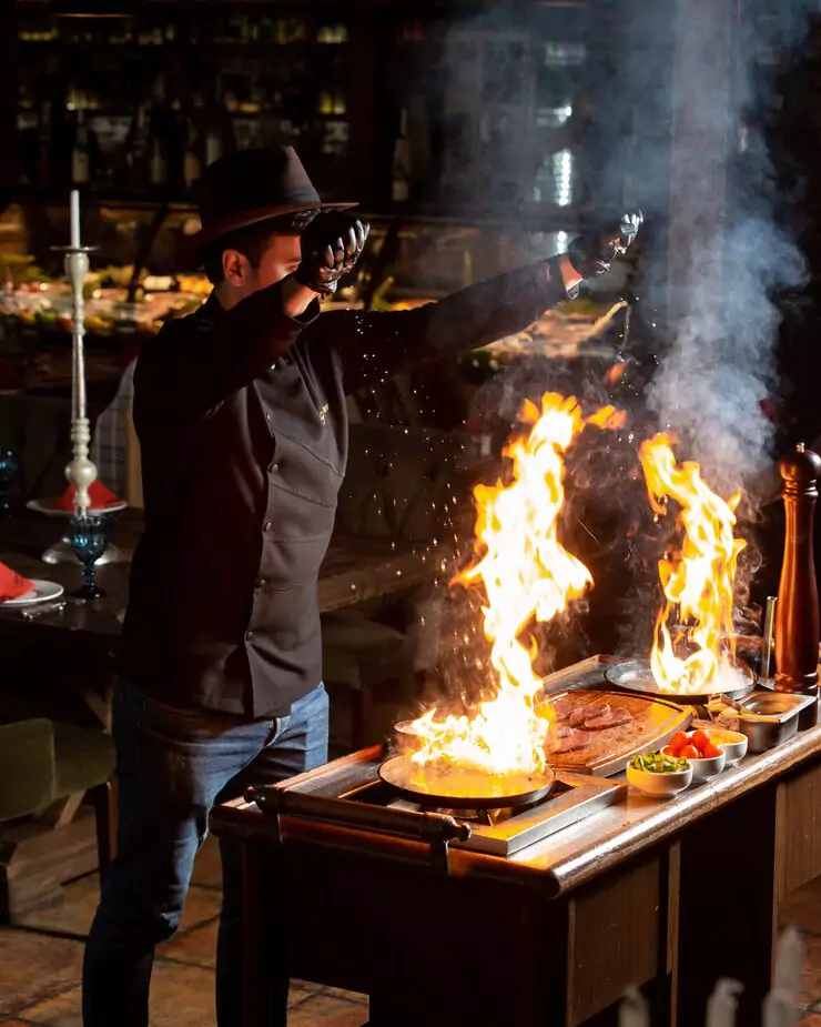 chef-putting-salt-into-two-burning-pans